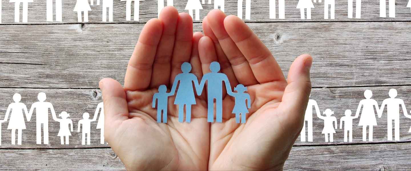 Hands holding a paper family